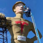 Golden Driller statue painted with Tesla logo and face transformed to Elon Musk.