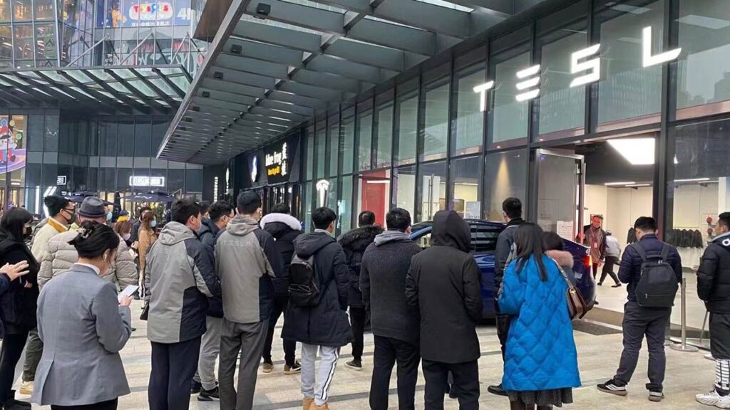 People gather outside a Tesla store in China to get a glimpse of the Model Y.
