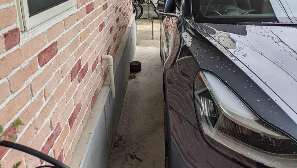 A Tesla Model 3 tightly parked in a Japanese home.