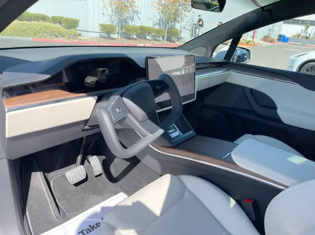 2021 Tesla Model X refresh interior (dashboard, Yoke steering, center touchscreen, front white seats).