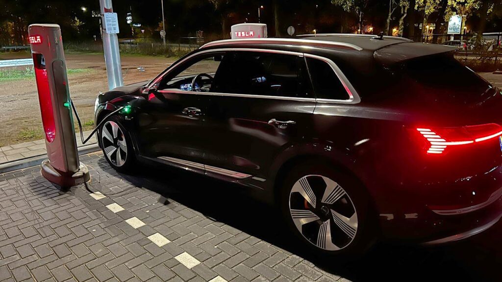 Audi e-tron charging at a Tesla Supercharger in Netherlands.