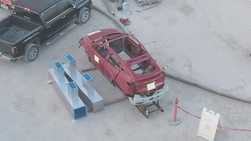 Tesla Model Y body frame with space for structural battery, laying outside the Model Y factory building at Giga Texas.