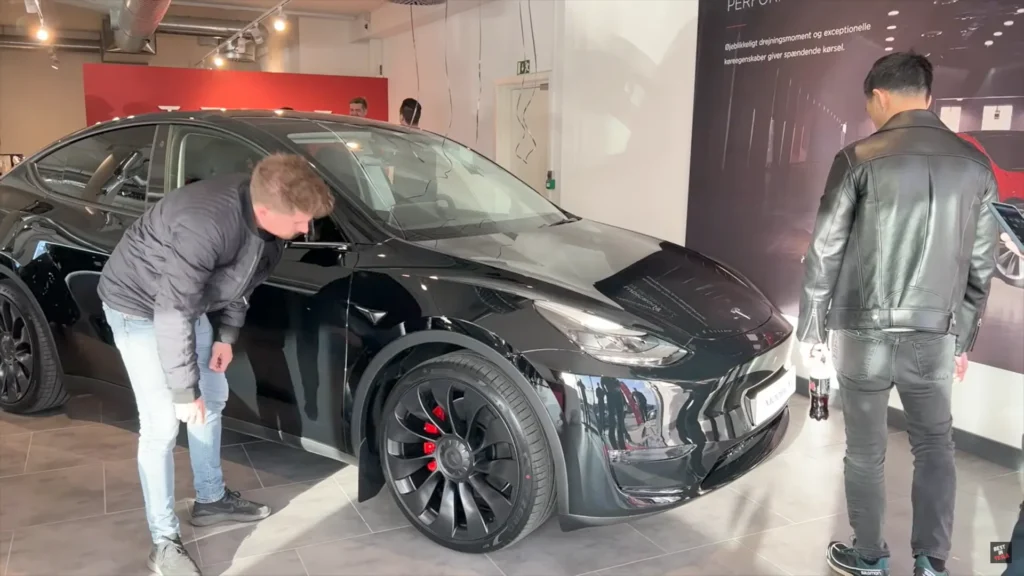 Owner of a Giga Berlin-made Tesla Model Y checking out his car for any quality issues before taking delivery.