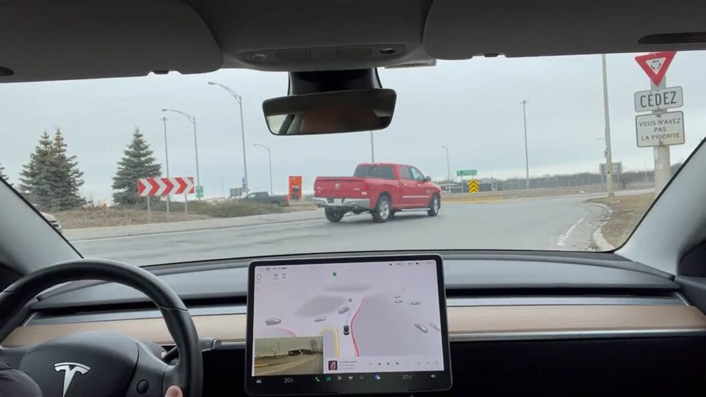 A Tesla Model 3 with FSD Beta 10.11.1 waiting for its turn to go through a roundabout in Montreal, Canada.