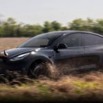 Tesla Model Y with bull horns on the hood running in vast fields of the state of Texas.