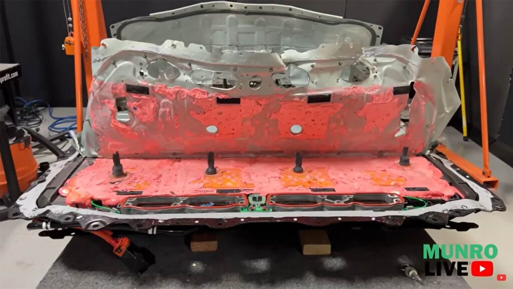 Tesla Model Y structural battery pack in the process of its teardown. The hard metal cover on top is not easy to remove.