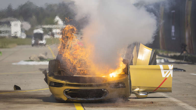 Tesla Model S burning after the fake battery fire erupts from the car at a demonstration by insurance company AXA.