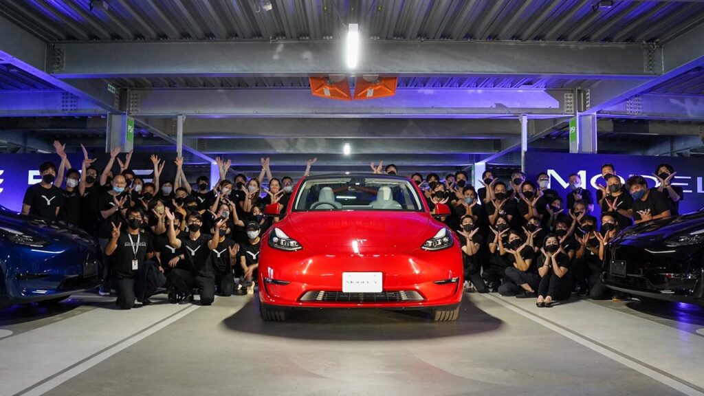 Employees of Tesla Japan celebrate the start of Model Y electric SUV deliveries.