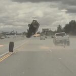 A wheel detached from a pickup truck and hits a car sending it high in the air. A Tesla vehicle behind automatically swerves to avoid the free rolling wheel.