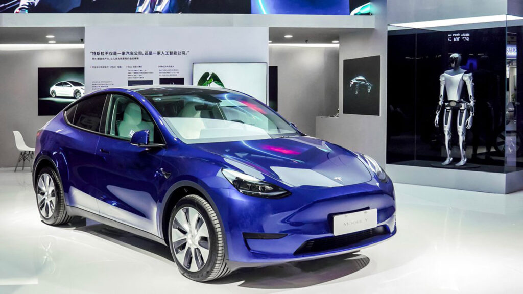 A blue Tesla Model Y and an Optimus Tesla Robot prototype on showcase at the 2023 World Artificial Intelligence Conference in Shanghai, China.