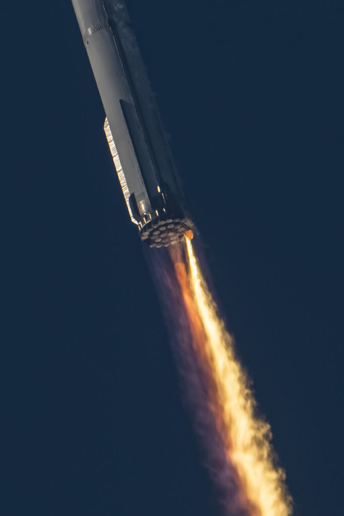Above photo: Starship 24 during the ascent as SpaceX loses communication to a majority of Raptor engines. Just a few engines can be seen firing and an anomaly can be observed as the engine bay catches fire (click/tap image to zoom in).