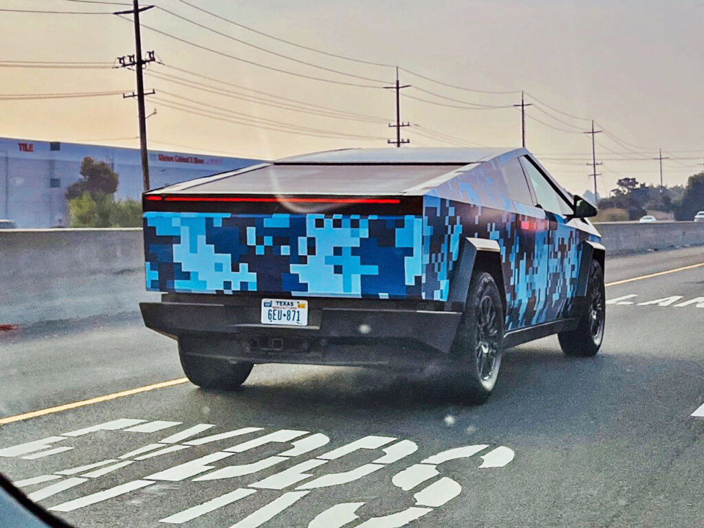 Tesla Cybertruck n a blue pixel wrap with the Texas manufacturer license plate.