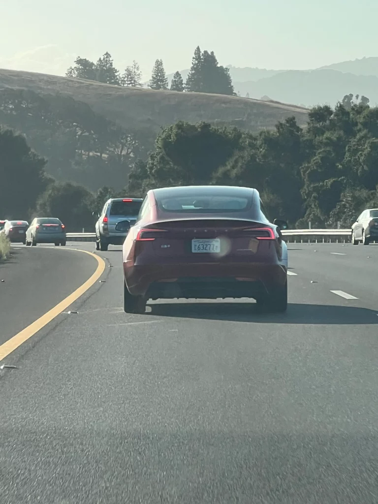 Tesla Model 3 Highland in Ultra Red color spotted on a California highway.