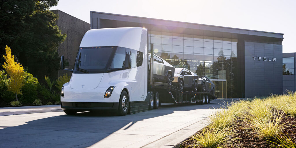 Tesla Semi truck with a car carrier trailer attached with a shipment of Cybertrucks out for delivery.