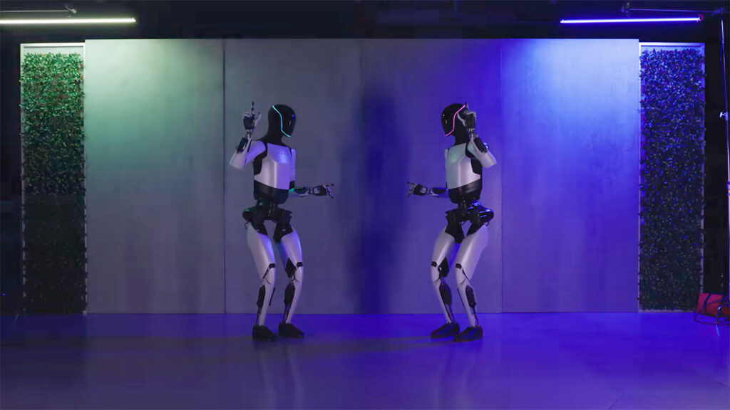 Two Tesla Optimus humanoid robots dancing.