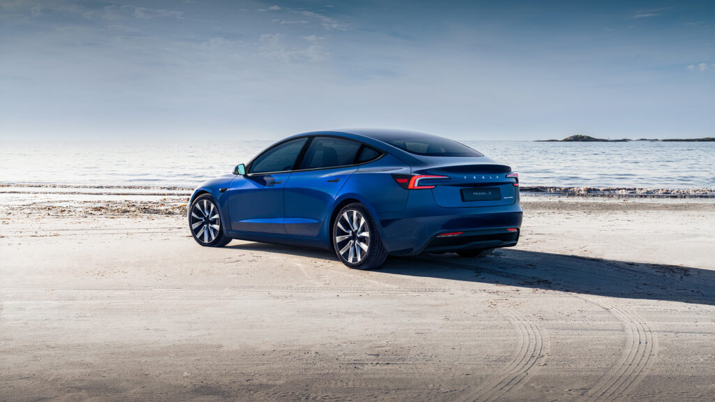 The design-refreshed Tesla Model 3 Highland in blue color parked on a beach.