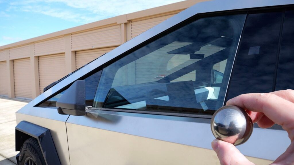 Cybertruck owner shows the steel ball that he uses to hit the truck's window glass.