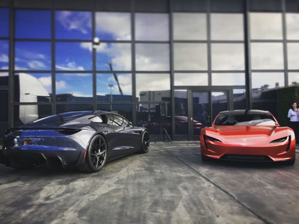 Two next-gen Tesla Roadster prototypes (grey and red) on display at a past company event.