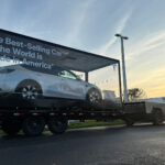 Tesla Model Y getting towed by the Cybertruck on US roads promoting the vehicle as the best-selling car of the world in 2023.