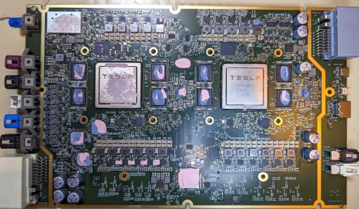 Two HW4 (AI4) chips installed on a Tesla car's main supercomputer motherboard.