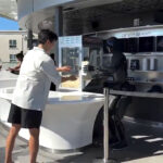 Tesla Optimus pulls back the popcorn bag to prank back at the YouTuber 'Korean Jay' at the Tesla Diner in Hollywood, California.