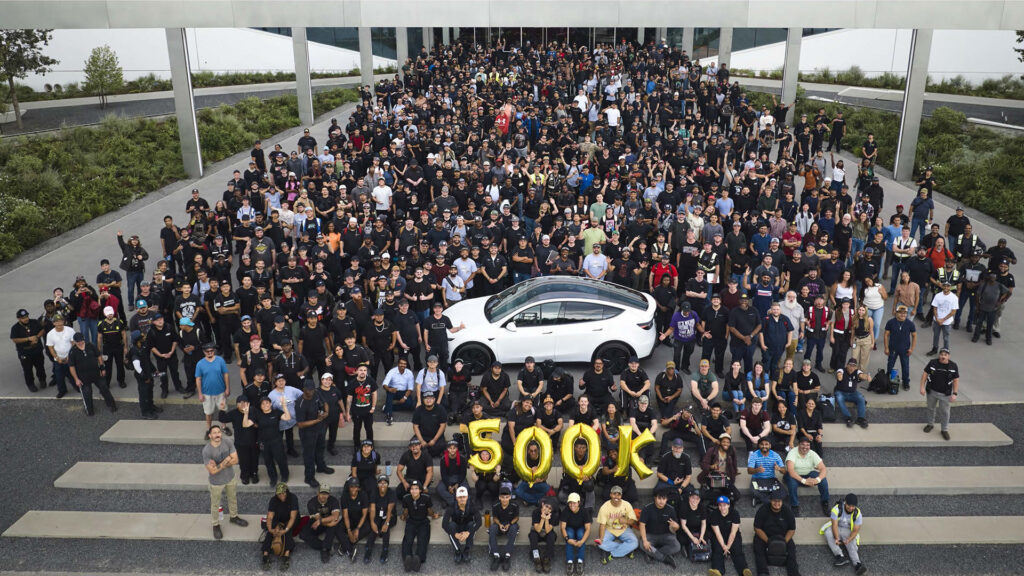 Tesla employees celebrate the production of the 500,000th vehicle at Giga Texas. Tesla makes Model Y electric SUVs and Cybertruck electric pickup trucks at this factory.