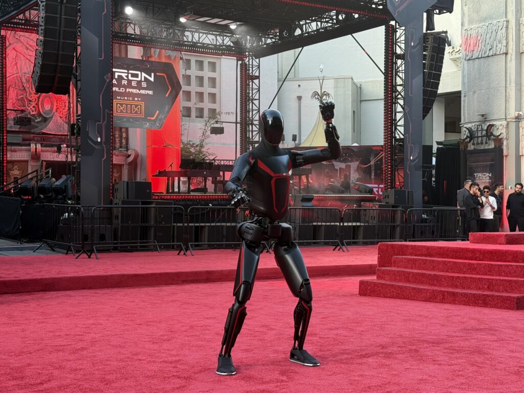 Tesla Optimus humanoid robot at the TRON: Ares premiere with a customized suit matching the movie's theme.