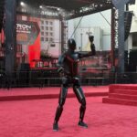 Tesla Optimus humanoid robot at the TRON: Ares premiere with a customized suit matching the movie's theme.
