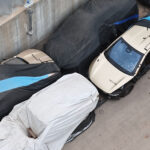Aerial drone shot of a Giga Texas storage lot showing multiple Tesla Cybercab robotaxis post crash safety testing.