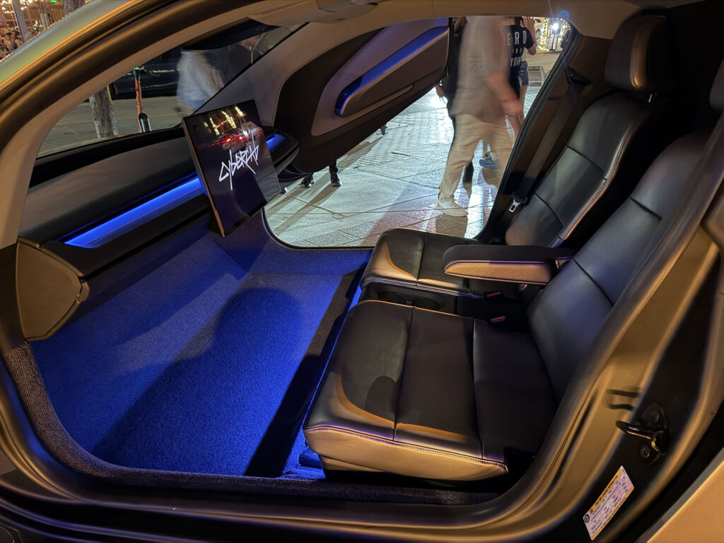 A view of the Tesla Cybercab robotaxi interior and ambient lighting (blue). This is an early production engineering test and display unit on display in Austin, Texas.