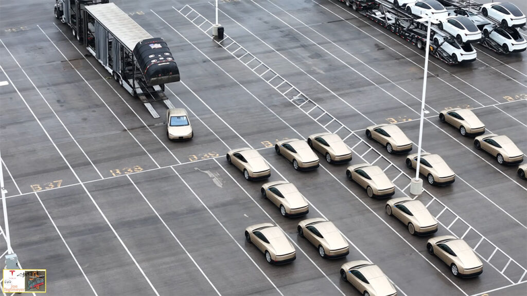 Tesla Cybercab robotaxi engineering test vehicles parked at the Giga Texas outbound lot and being loaded onto a car carrier trailer for deliveries to various cities and US states for testing and validation (Monday, 9th March 2026).