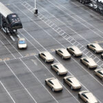Tesla Cybercab robotaxi engineering test vehicles parked at the Giga Texas outbound lot and being loaded onto a car carrier trailer for deliveries to various cities and US states for testing and validation (Monday, 9th March 2026).