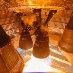 A single Raptor 3 engine firing under Starship 40 (Flight 13 upper stage) on a static fire test stand at the Masseys Outpost, Starbase, Texas.
