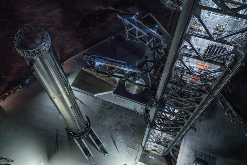 Aerial view of the Flight 14 Starship Super Heavy Booster 21 (left) and the Starbase Pad 2 launch tower (right).