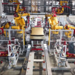 A Tesla Cybercab moving towards the end of the production line as robots have finally attached the body panels after module integration.