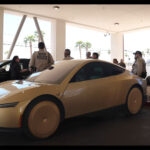 A Tesla Cybercab and a Model Y Robotaxi parked side-by-side as a Tesla executive briefs Austin Metro Police on safety and emergency features of the self-driving vehicles.