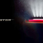 Screenshot of the official Tesla Roadster launch countdown webpage. The teaser image on the right side shows four SpaceX thrusters firing and an obscured view of the rear fascia (brightness increased to lighten shadows).