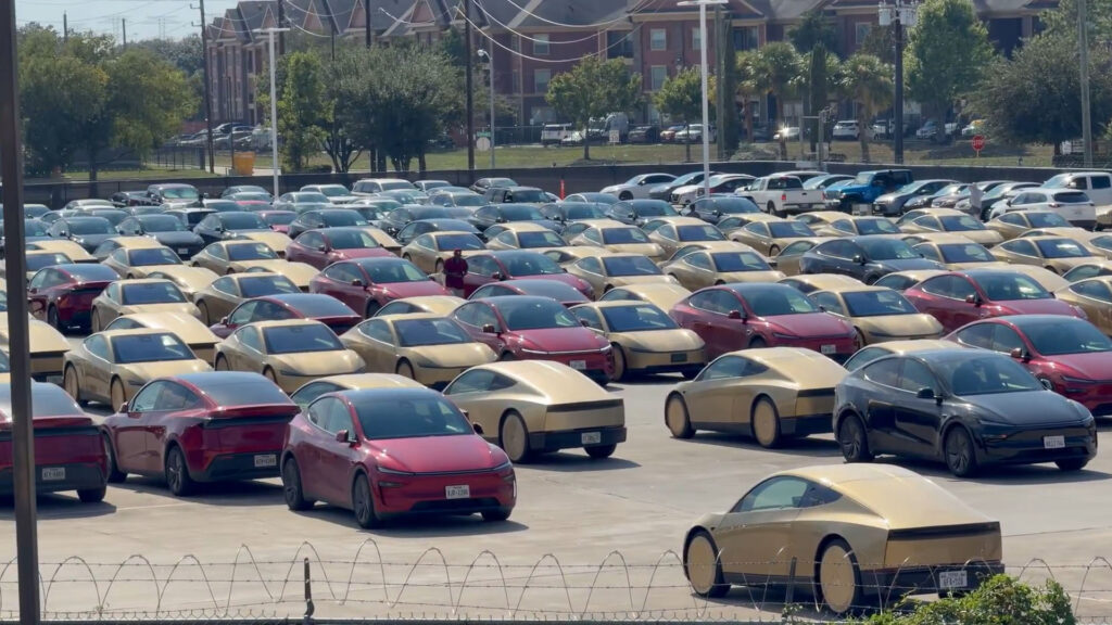 A large parking lot filled with Tesla Cybercabs and Model Y Robotaxis in Houston, Texas.