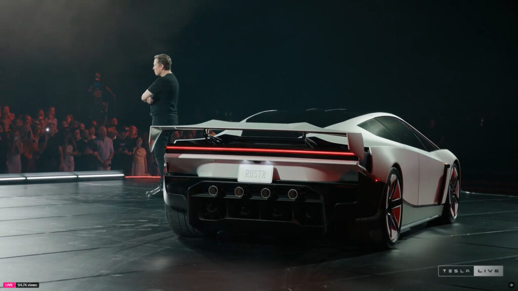 Tesla Roadster's wing spoiler is activated as Elon Musk presents the car (standing behind it in the photo).