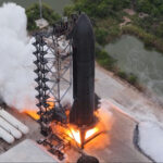 Aerial view of Flight 15 Starship 42 as it performs a six-engine static fire test at the Massey's Outpost, Starbase, Texas.