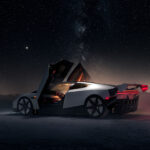 Next-gen Tesla Roadster's side profile view as its scissor doors are open, and spoiler and front fender are activated and retracted (active aerodynamics). The photo is taken at night under a sky full of stars with the title 'Roadster: Out of This World'.