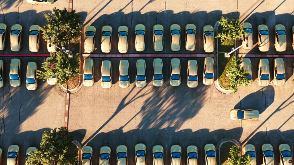 Aerial view of the Tesla Cybercab robotaxi lot in Austin, Texas with many vehicles in sight.