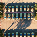 Aerial view of the Tesla Cybercab robotaxi lot in Austin, Texas with many vehicles in sight.